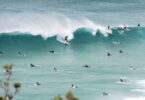 Surfers riding waves off the Queensland coast, near the site of a sewage treatment plant upgrade.